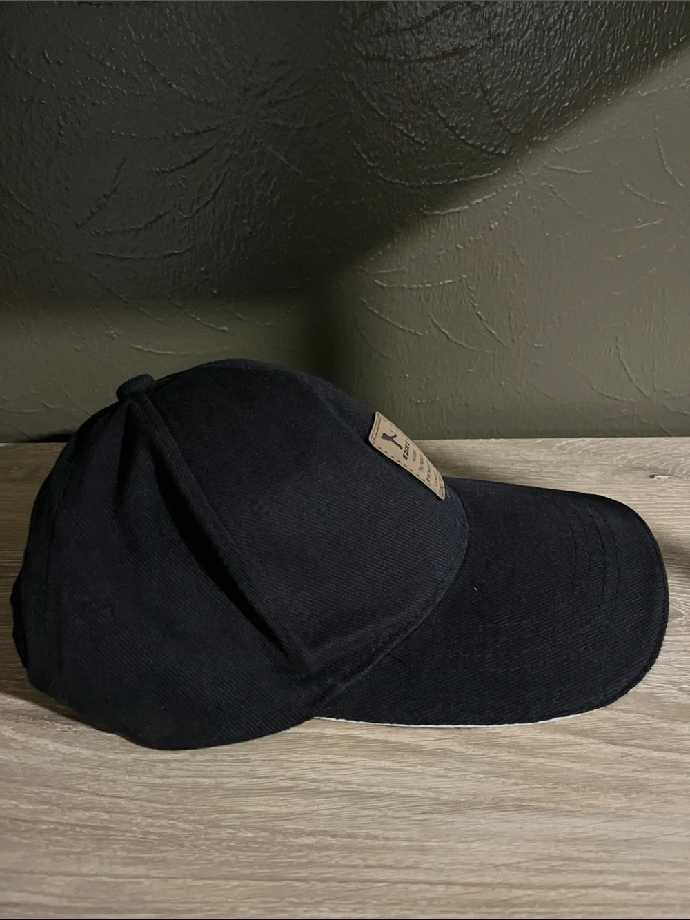 Black Baseball Cap With a Brown Logo And Adjustable Strap